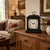 Table clock on wooden dresser, black case, white dial with flowers, gold handle