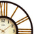 Wanduhr mit rundem dunklen Metallgehäuse, beigem Zifferblatt und goldenen Strahlen