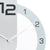 Close-up of wall clock: metal hands, numbers in a ring, white casing, black digits