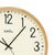 Wall clock with beige dial, black hands, and light wood frame, AMS.
