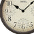 Wanduhr mit braunem Metallgehäuse und beigem Zifferblatt, schwarze Zeiger und Messskala