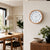 Wall clock with wood-look frame and white dial on the wall