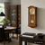 Wanduhr an der Wand mit Holzgehäuse und Pendelgewicht im unteren Sichtfenster