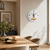 Wall clock on the wall: round white dial with black hands and gold movement