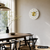 Wanduhr an der Wand: weißes Ziffernblatt mit goldenen Strichindizes und Messing-Zentrum