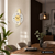 Wanduhr mit weißem Zifferblatt, goldfarbenen Holz- und Messingakzenten sowie schwarzem Zeiger