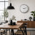 Round wall clock with white dial, black hands, and stainless steel frame