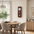Wooden wall clock in wooden frame with round dial and pendulum, on the wall