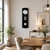 Wall clock on the wall: black case with round pendulum, white dial