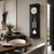Wall clock in black frame with glass front, round clock face, and stainless steel chime rods