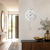 Wall clock with white dial, black hands, and long curved hanger