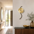Wall clock on the wall with a gold-colored dial, black hands, and a dark curved part
