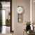 Wall clock with white dial, wooden case, and pendulum ball