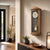 Wall clock with acorn-colored wooden case, pendulum bell, and blue-gray dial