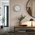Wall clock on the wall with a round metal frame and a white dial