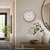 Wanduhr an der Wand mit Holzoptik-Rahmen und weißem Zifferblatt, schwarze Zeiger