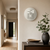 Round LED word clock with gray dial on the wall, subtle text display
