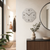 Wall clock on the wall with a gray dial, numbers 3, 6, 9, 12, and hands