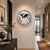 Round wall clock in hallway: silver frame, white dial, black world map