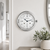 Round analog table clock with silver casing and white dial, blue hands