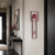 Wall clock with red frame and rectangular inner casing, visible red pendulum