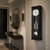 Wall clock with black frame and glass front, round dial and pendulum body