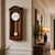 Wooden wall clock with wooden frame, round dial, and gold pendulum ball