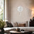Wall clock on the wall with a round white dial and a curved suspension