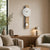 Wall clock with wooden case and white pendulum on the wall
