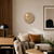 Round LED word clock in wood look above sofa, illuminated text
