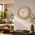 Round wall clock with beige wood-look frame and white dial, Roman numerals