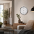 Wall clock on the wall with a white dial, black numbers, and hands