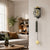Wall clock on the wall with a round dial, golden dome, and pendulum cylinder