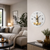 Wall clock on the wall: round white dial with black hands and gold movement