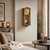 Pendant wall clock on the wall in a cherry wood-colored case with a gold dial