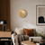 Table clock with round dial in antique brass look and word display above sofa