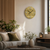 Round wall clock on the wall with wood-look dial, metal numbers, and anthracite hands