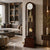 Grandfather clock in the room: dark wood casing, white dial, and gold-colored pendulum rods