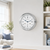 Round analog table clock with silver frame, white dial, and blue hands