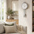 Wall clock with round dial, vertical metal rods, and silver ball pendulum