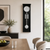 Wall clock in black housing with white dial and spherical pendulum