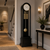 Grandfather clock with black casing, white dial, and gold pendulum rods