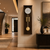Walnut-colored wall clock with round dial and brass pendulum with ball weight