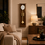 Wooden wall clock in living room: white dial, gold-colored gong rods and pendulum disc