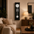 Wall clock in black housing with white dial and silver ball pendulum