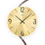Close-up of a wall clock: gold-colored dial with black numbers and hands