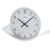 Close-up of the table clock: gray dial with black hands, round hour markers
