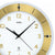 Detailansicht der Wanduhr: goldenes Zifferblatt, schwarze Zeiger und silberner Rahmen