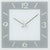 Nahansicht der Wanduhr mit AMS-Logo, blau-grauem Zifferblatt und silbernen Zeigern