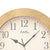 Detail view wall clock: beige frame, white dial with Roman numerals and hands